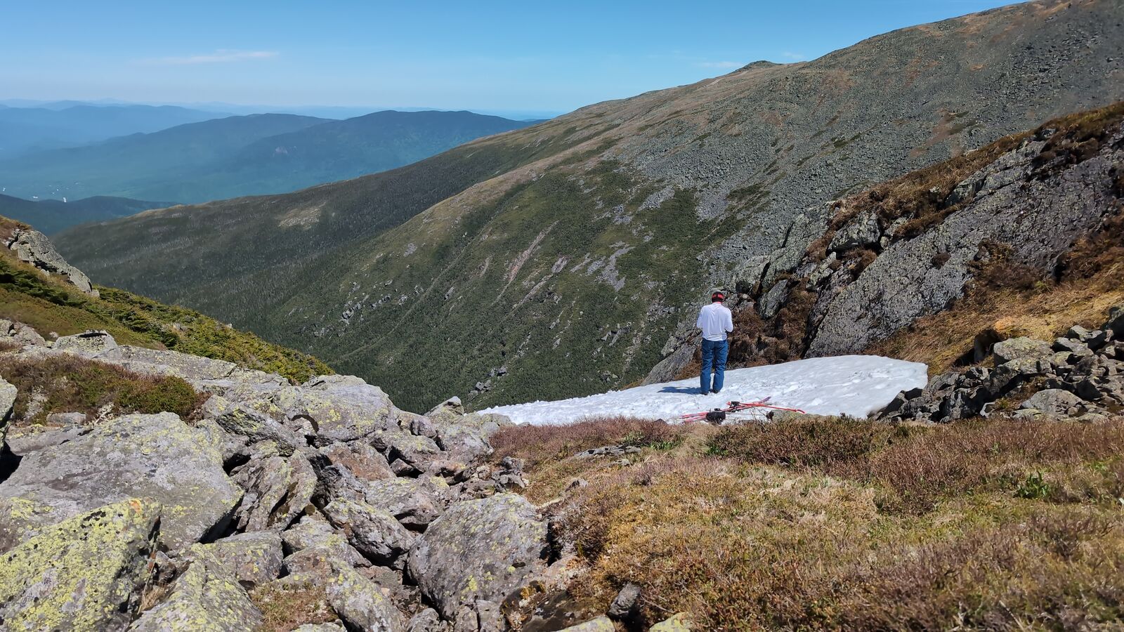 Hiker on late-season snowfield, western slopes
